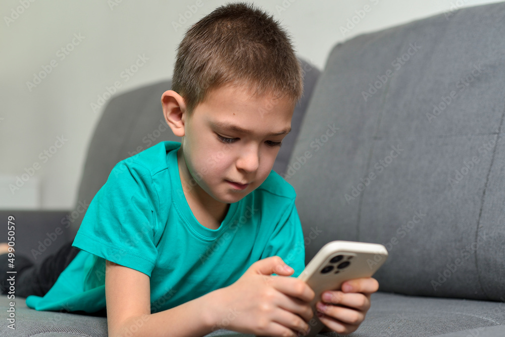 Kid boy holding a smartphone and messaging Kid boy holding a smartphone and messaging