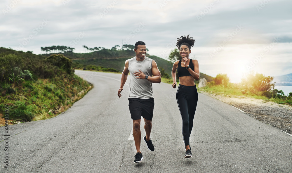 Fototapeta premium Clocking some workout time in the fresh air. Shot of a sporty young couple exercising together outdoors.