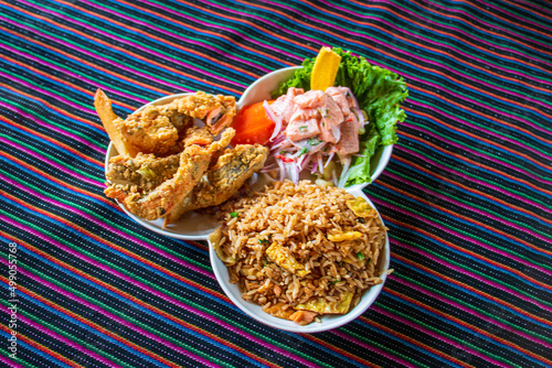 Peruvian food Trio marine chaufa rice ceviche fish pork rinds Traditional food on a lliclla photo