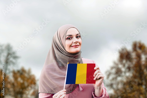 Muslim woman in hijab holds flag of Romania