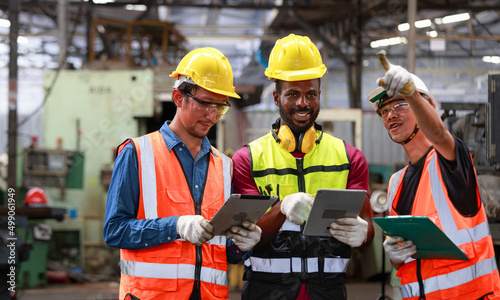 A team of Asian and African American male engineers congratulated. Availability of maintenance plans for industrial machines