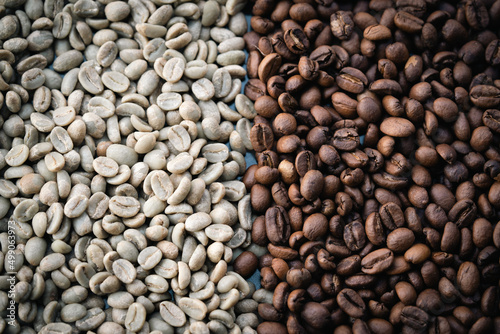 A pile of natural raw and brown roasted coffee beans.