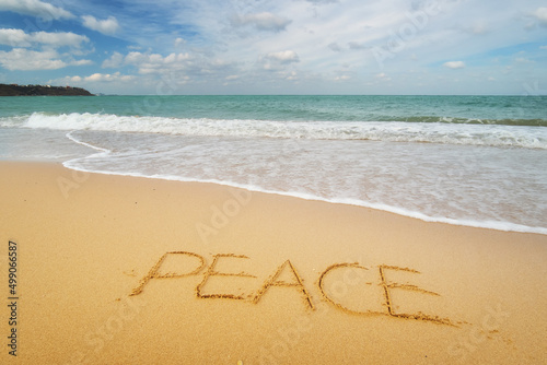 Peace word on sea sandy shore.