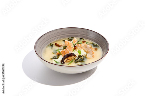 Japanese food - miso soup with tofu, wakame, prawn and shiitake mushroom. Miso soup with shrimp in ceramic bowl on isolated white background.
