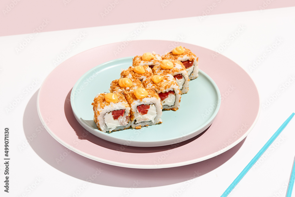 Alternative maki roll with chicken on coloured background. Sushi roll with chicken, cheese and tomato inside, bread crumbs outside. Maki sushi in minimal style. Japanese menu concept. Alternative maki roll with chicken on coloured background. Sushi roll with chicken, cheese and tomato inside, bread crumbs outside. Maki sushi in minimal style. Japanese menu concept.