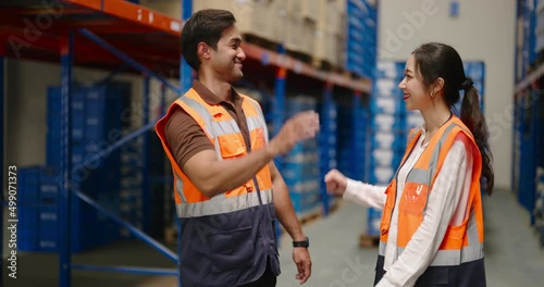 portrait of Asian warehouse workers in protective vest standing in large warehouse