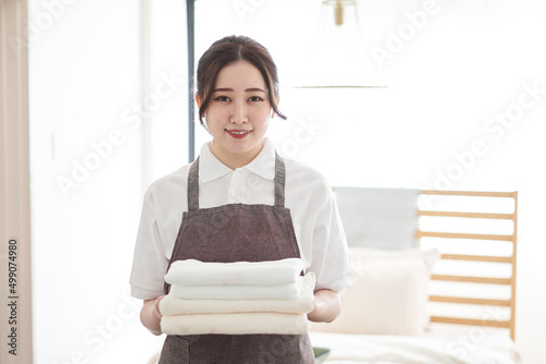 タオルを畳んで片付けるアジア人女性