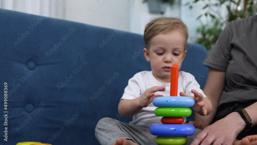 Happy cute family at home. Baby play with colored toys. Educational games for preschooler child. Mom helps child to play and have fun. Family happy education concept. Mom help in learning about world. Happy cute family at home. Baby play with colored toys. Educational games for preschooler child. Mom helps child to play and have fun. Family happy education concept. Mom help in learning about world.