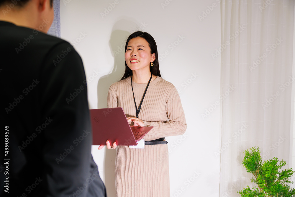 ノートパソコンを持って話しかける日本人女性 ノートパソコンを持って話しかける日本人女性