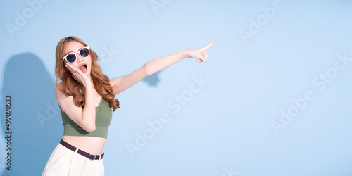 Beautiful young Asian woman on blue background, summer vacation concept