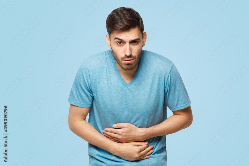 Abdominal pain or ache, young sick man touching his stomach Abdominal pain or ache, young sick man touching his stomach
