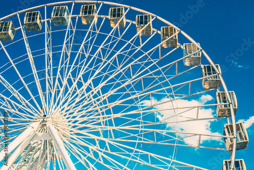 Ferris Wheel against blue cloudy sky on sunny weather