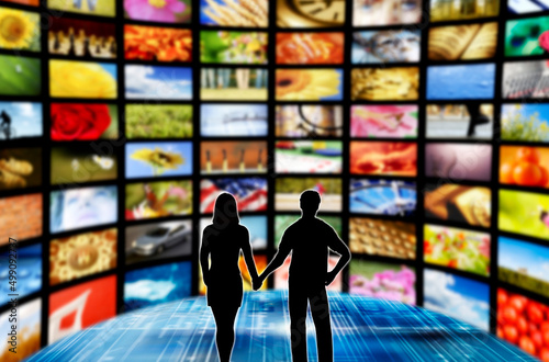 couple man and woman in a room with many screens, broadcasting and online streaming concept