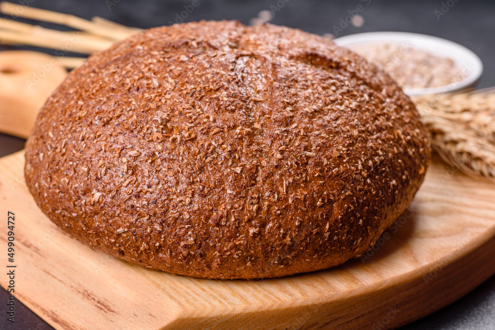 Fresh baked brown bread with ears and grains of wheat Fresh baked brown bread with ears and grains of wheat
