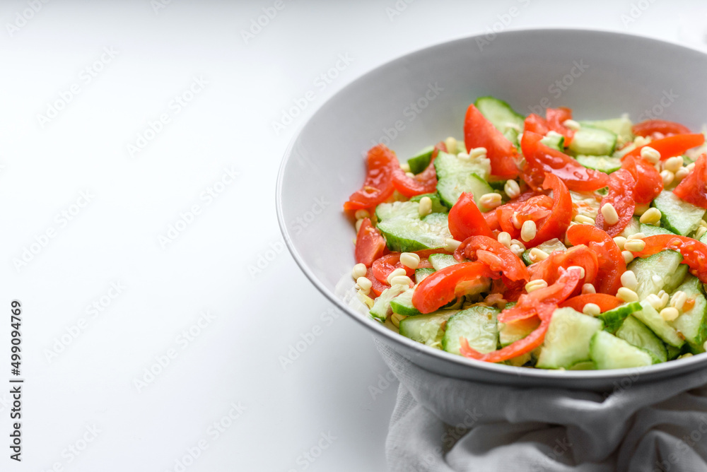 A delicious salad with beans, tomatoes and cucumbers on a white background