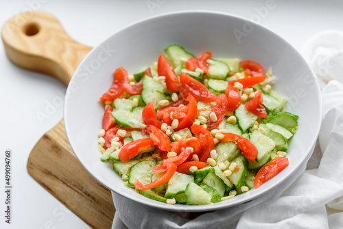 A delicious salad with beans, tomatoes and cucumbers on a white background