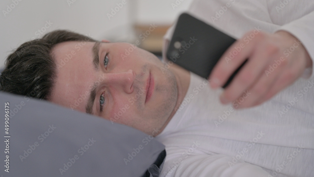 Man using Smartphone while Sleeping in Bed, Close up Man using Smartphone while Sleeping in Bed, Close up