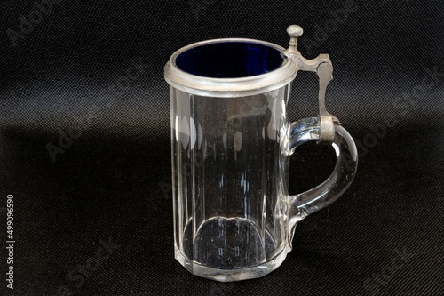 Antiker Bierkrug  mit Deckel aus Glas und Zinn; freigestellt vor schwarzem Hintergrund photo