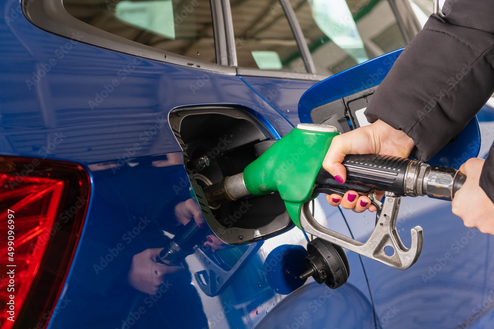 Woman refuels a car with gasoline. Rise in fuel prices. Sanctions against Russia and the oil embargo concept. Woman refuels a car with gasoline. Rise in fuel prices. Sanctions against Russia and the oil embargo concept.