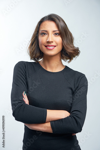 Fotografiet Portrait of beautiful young woman smiling, standing with arms crossed over white