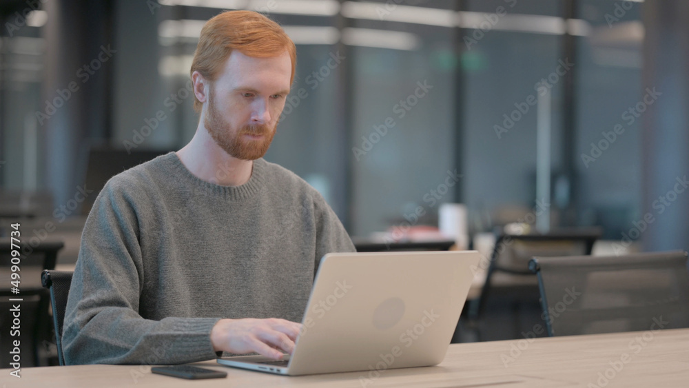 Young Man Working on Laptop in Office Young Man Working on Laptop in Office