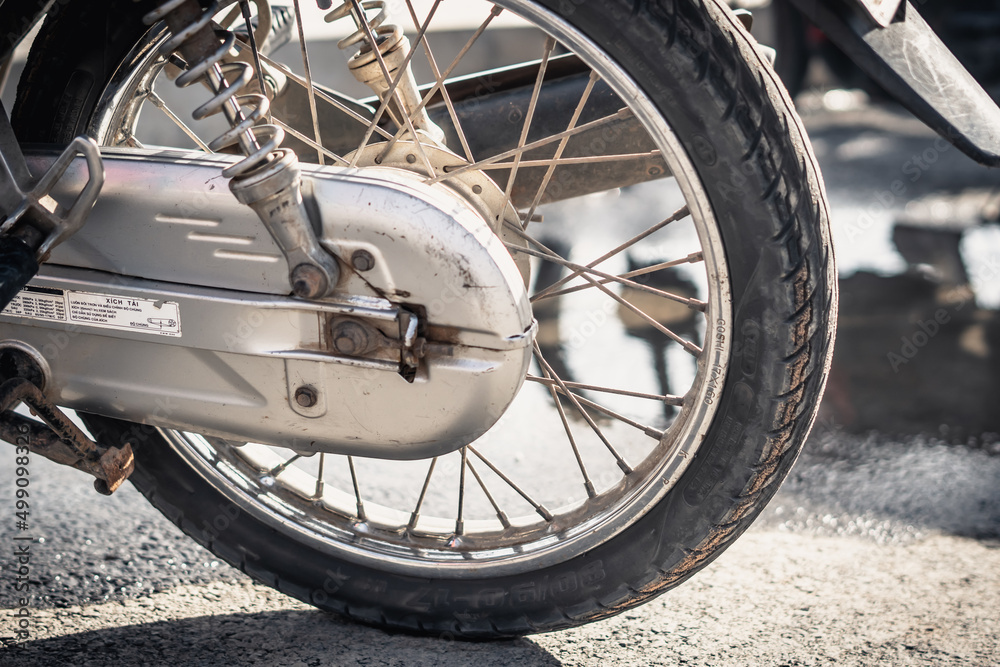 Abstract real photo close up sport motorcycle auto moto bike, back wheel spokes brakes shock absorbers aluminum gearbox housing. Asphalt background. Travel hobby dream speed open season. Vintage Abstract real photo close up sport motorcycle auto moto bike, back wheel spokes brakes shock absorbers aluminum gearbox housing. Asphalt background. Travel hobby dream speed open season. Vintage