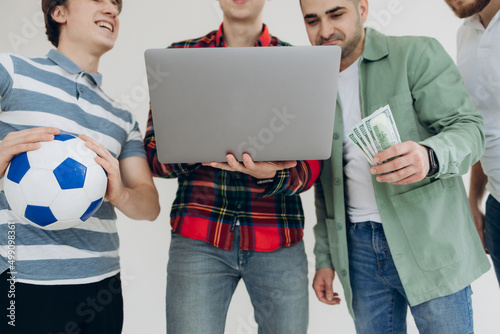 group of guys male friends looking at sports betting coupon on laptop. Decide which team to bet on. Gambling concept. Sports betting. Online betting
