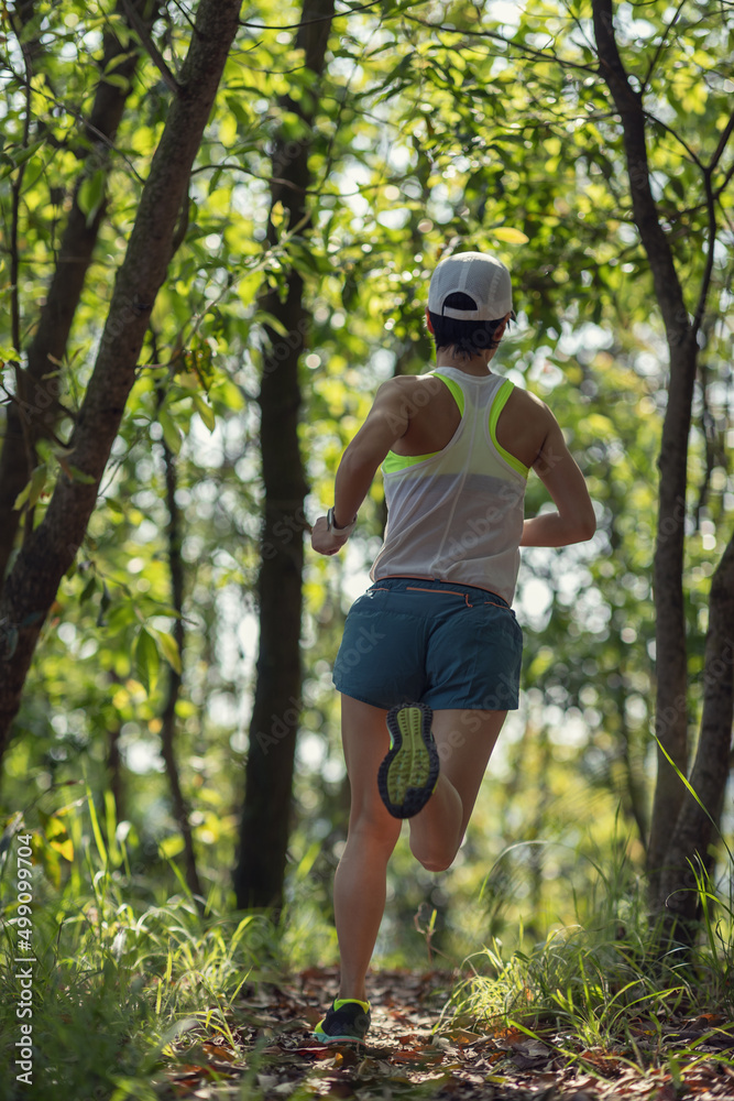 Woman runner running on forest trail Woman runner running on forest trail