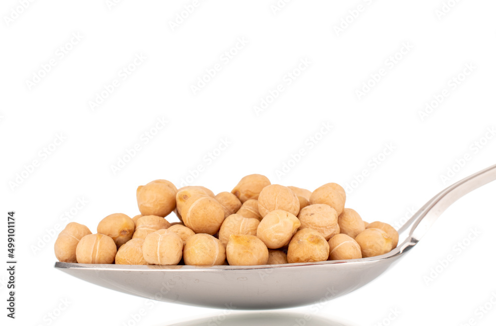 Several uncooked hummus grains with a metal spoon, macro, isolated on white. Several uncooked hummus grains with a metal spoon, macro, isolated on white.