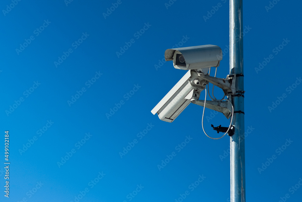 outdoor surveillance video camera, in the photo there are two video cameras against the blue sky outdoor surveillance video camera, in the photo there are two video cameras against the blue sky