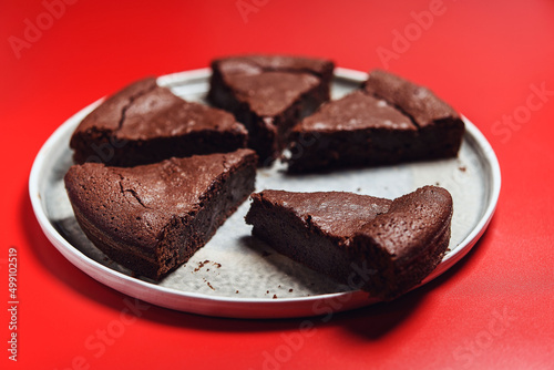 Chocolate Flourless Cake on red background. Soft chocolate gÃ¢teau or Brownie cake. Selective focus photo
