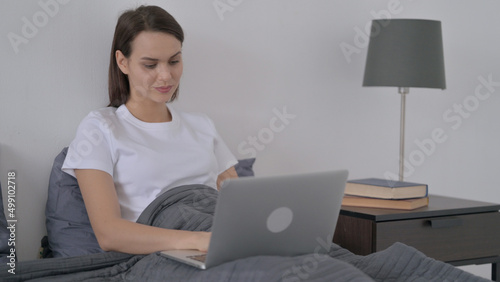 Woman Working on Laptop in Bed