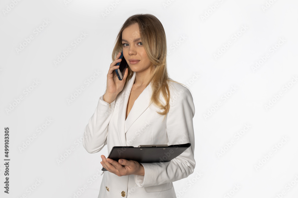 successful beautiful businesswoman with a folder of documents calls on the phone successful beautiful businesswoman with a folder of documents calls on the phone