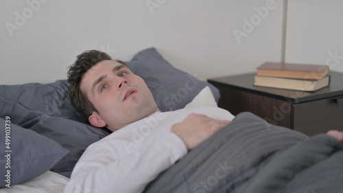 Man Waking up from Nightmare in Bed
