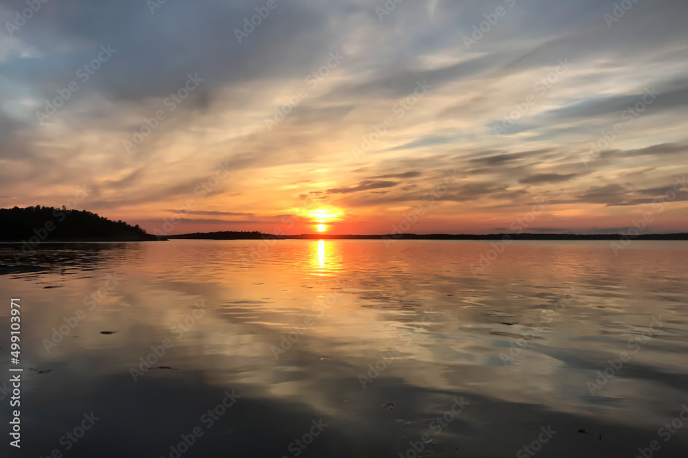 Obraz premium A beautiful sunset over a lake in the Swedish summer