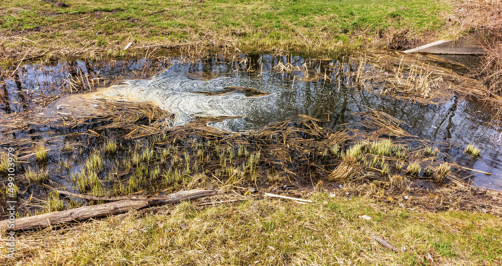 a stream with foam flowing in the spring a stream with foam flowing in the spring