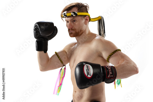 Half-length portrait of muscled man, thai boxer in sports uniform posing isolated on white studio background. Sport, muay thai, competition, fight club concept © master1305