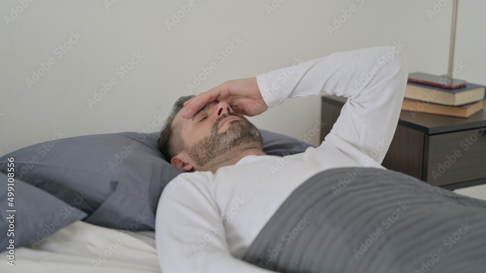 Man having Headache while Sleeping in Bed Man having Headache while Sleeping in Bed