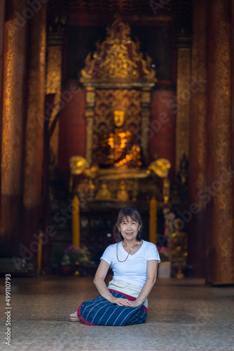 Asian Buddhist women pray, and make merit at Wat Ton Kain temple is the old wooden temple a famous place religious travel destination in Chiang Mai, Thailand.