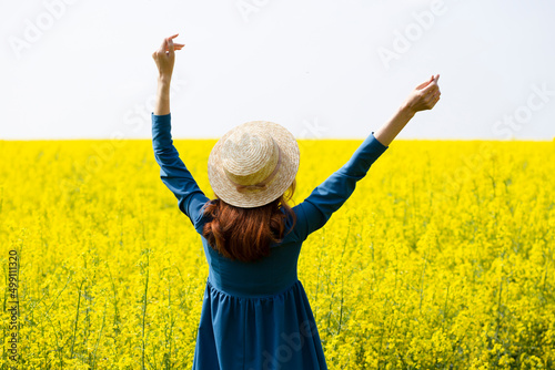 girl walking in a field of yellow rapeseed