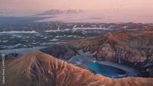 Blue lake in the crater of Gorely volcano in Kamchatka peninsula, Russia. Aerial drone view. Pink clouds and sky at sunrise over the volcanoes.  Beautiful summer landscape
 photo