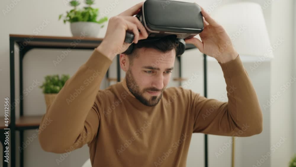 Young hispanic man playing video game using virtual reality glasses at home Young hispanic man playing video game using virtual reality glasses at home
