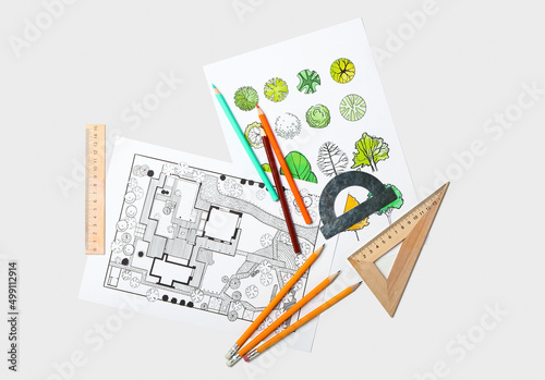 Paper sheets with sketches for landscape design and stationery on light background