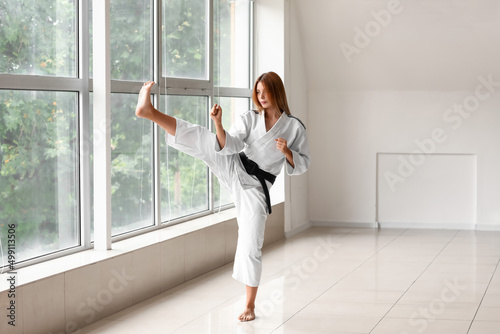 Young woman practicing karate in gym photo