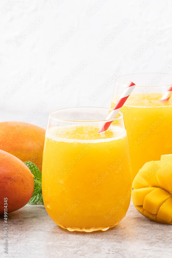Fresh beautiful delicious mango juice smoothie in a glass cup on gray table background. Fresh beautiful delicious mango juice smoothie in a glass cup on gray table background.