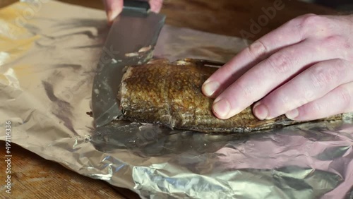 Smoked Bream body being splitted with knife