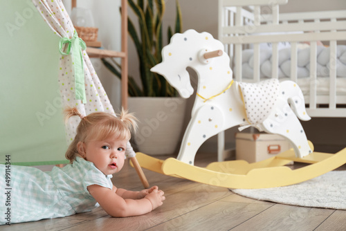 Adorable baby girl in playroom