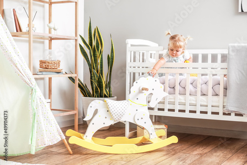 Adorable baby girl in bed n...