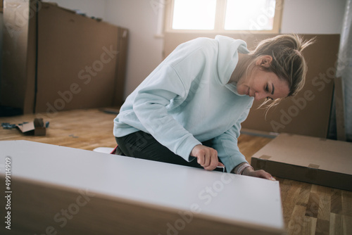 Fotografiet Woman using hex key for assembling furniture