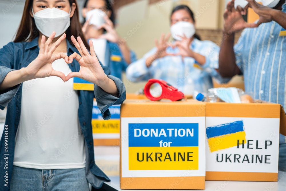 Volunteers preparing food donations for people in need in Ukrain., Humanitarian aid concept.Hands making sign Heart .